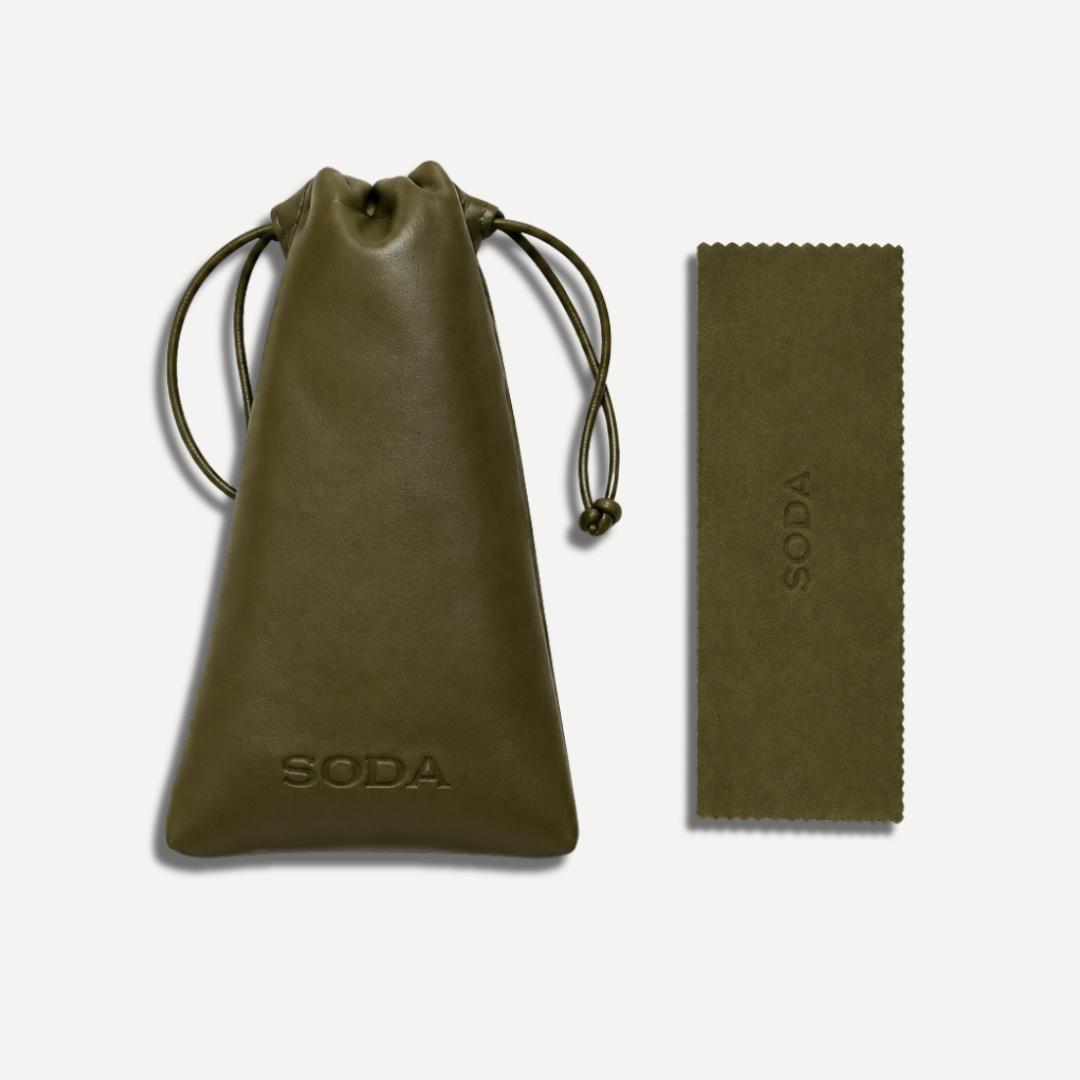 An olive green leather drawstring pouch and a matching rectangular leather accessory with embossed SODA branding, displayed on a clean off-white background.